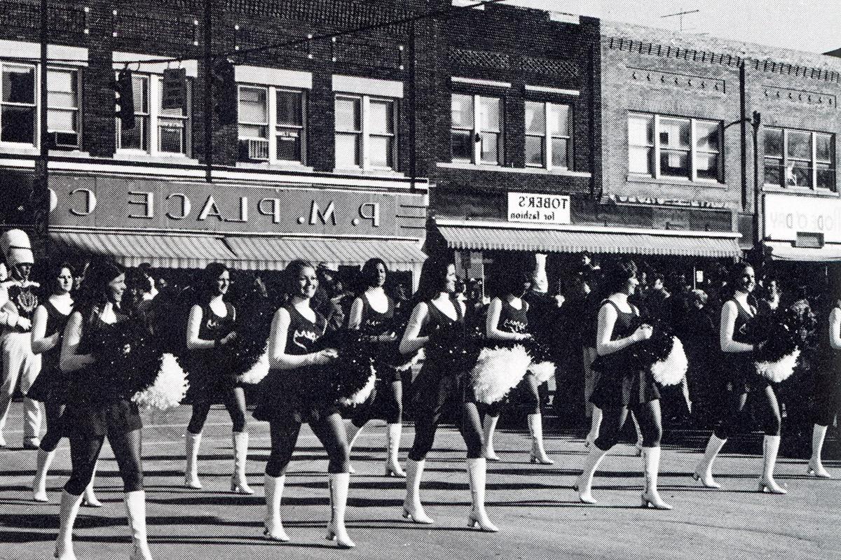 A P.M. Place Co. store stood in the background as the Bearcat Steppers and Bearcat Marching Band marched through downtown Maryville during the 1974 Homecoming parade. (Tower yearbook photo)